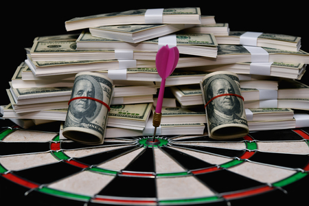 Finance Business Concepts. Businessman is playing darts. Businessmen are aiming for work. Businessman looking at a lot of money.の写真素材