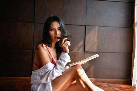 Sexy concept. Sexy painters are drawing in the bedroom. Beautiful girls are thinking of creating art in the home.の写真素材