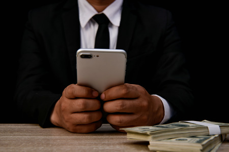 Finance Business Concepts. Lots of money on a black background. Investments are a necessity of business. Businessman looking at a lot of money.の写真素材