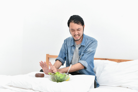 Healthy eating concept. Asian men are choosing to eat with their hands. Asian men want to eat healthy foodの写真素材