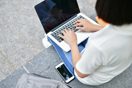 Business Concepts. Beautiful girl playing computer in the building. Young businesswoman is working happily.の写真素材
