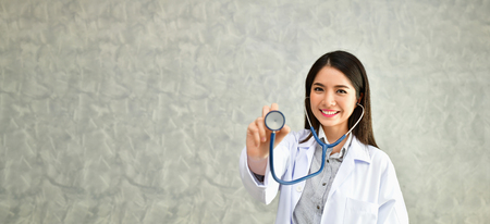 Smiling doctor posing in the office, She is wearing a stethoscope, medical staff on the hospital backgroundの写真素材