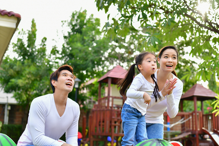 Family Concept. Family is doing happy activities at Playground. Parents with children are playing in the garden.の写真素材