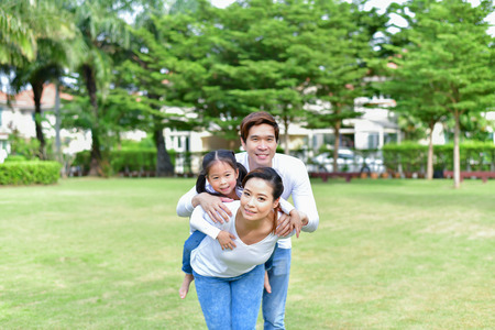 Family Concept. Family is doing happy activities at Playground. Parents with children are playing in the garden.の写真素材