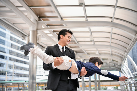 Family concept. Dad and son are playing fun toys. A businessman is carrying his son inside the city.の写真素材