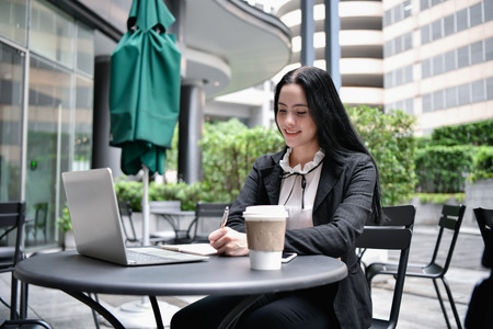 Business concept. Young businesswomen in the coffee shop. Young business people are working happily.の写真素材