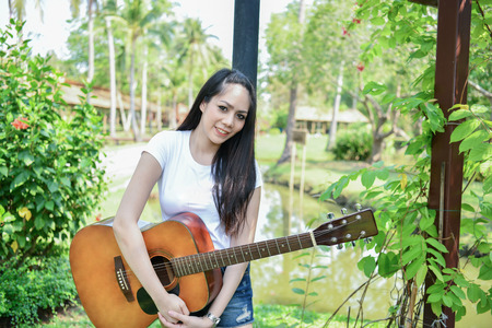 Music Concepts. Asian girls playing guitar. Asian women relaxing with music. Asian women have a...