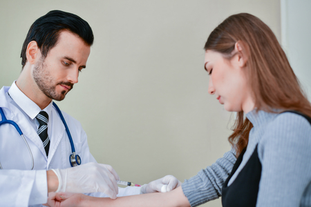 Health Concepts. The doctor is about to inject the patient. The doctor is treating the patient fully.の写真素材