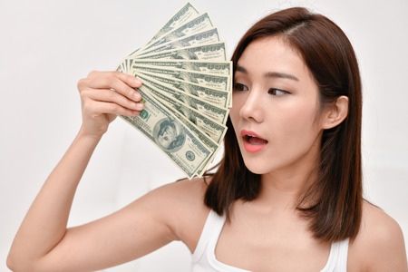 Financial concept. Beautiful girl is happy in her income. Beautiful women are counting money home.の写真素材