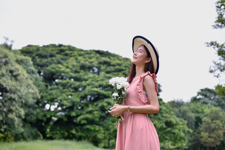 Holiday concept. Beautiful girl is getting flowers. Beautiful girl enjoys the scenery and nature.の写真素材