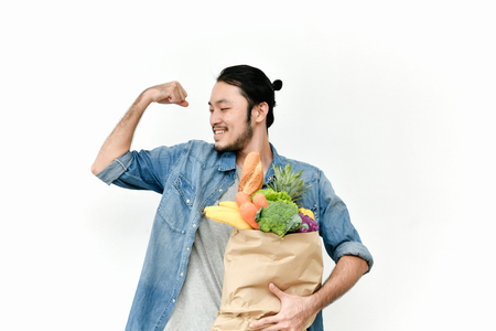 Young men are choosing to buy food happily. Young men choose fresh, clean fruits and vegetables.の写真素材