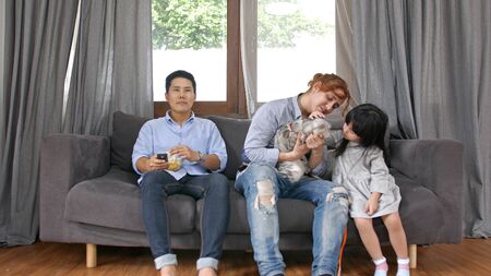 Family concept. The girl is playing a cat with her brother.
