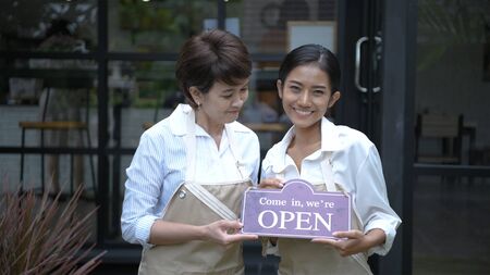 Coffee shop concept. The waitress is opening a coffee shop in bright. 4k Resolution.の写真素材