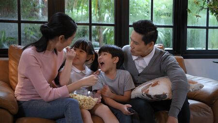 Holiday concept. The family is watching tv cheerfully. 4k Resolution.の写真素材