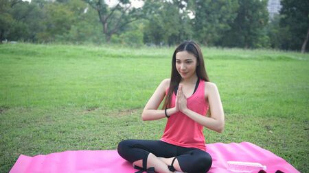 Exercise concepts. Beautiful women are practicing yoga in the middle of nature. 4k Resolution.の写真素材