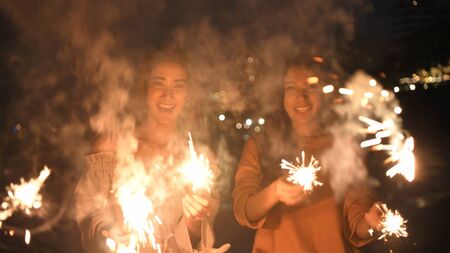 Holiday concept. Asian girls playing fun fireworks on the beach. 4k Resolution.の写真素材