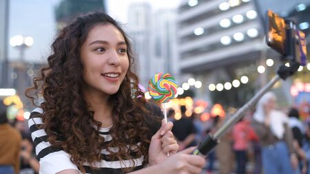 Holiday concept. A beautiful girl is filming video at a celebration. 4k Resolution.