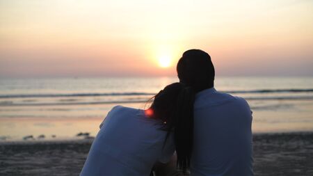 Holiday concept. Young lovers making heart-shaped hands on the beach. 4k Resolution.の写真素材