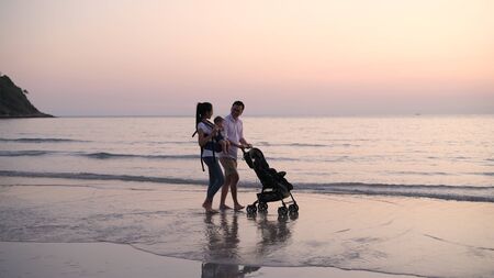 Holiday concept. Parents are pushing the baby cart on the beach. 4k Resolution.の写真素材