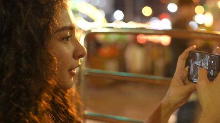 Holiday concept. A beautiful girl taking a high-angle photo on the ferris wheel. 4k Resolution.