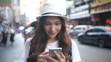 Travel concept. Beautiful girl searching for information on mobile phones. 4k Resolution.の写真素材