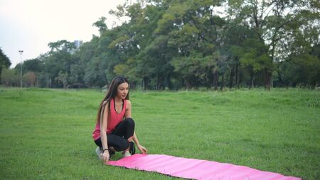 Exercise concepts. Young women preparing for exercise by laying yoga mats in the park. 4k...