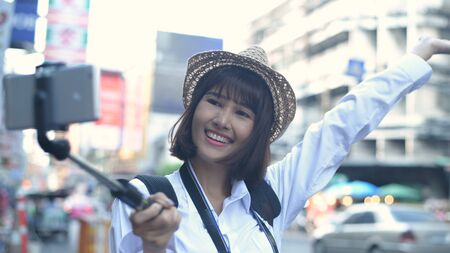 Travel concept. Beautiful girls are broadcasting live tourism in the city. 4k Resolution.の写真素材