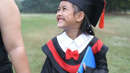 Educational concepts. The girl is walking hand in hand with the mother on graduation day. 4k Resolution.の写真素材