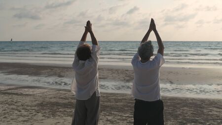 Holiday concept. Old people are practicing fresh breath by the sea.