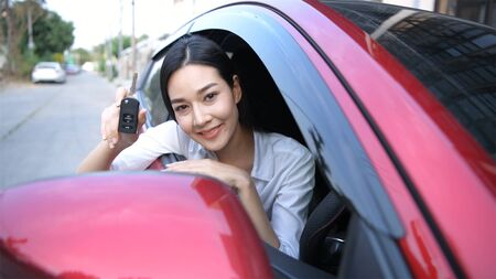 Travel Concept. The girl is smiling happily with the success of her first car. 4k Resolution.の写真素材
