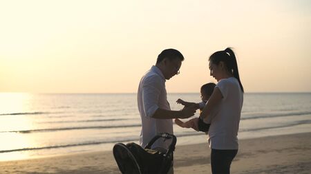 Holiday concept. Parents playing with baby on the beachの写真素材
