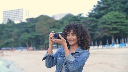 Holiday concept. A beautiful girl taking a photo with a digital camera. 4k Resolution.