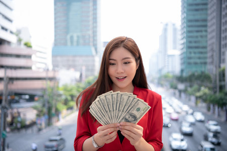 Asian businesswoman counting money in the city.の写真素材