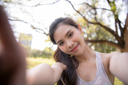Asian woman taking a selfie in the city.