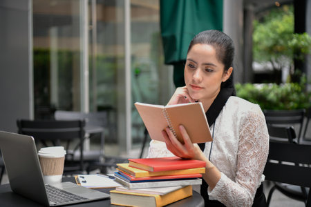 Caucasian woman studying in coffee shop. She was reading a book intently.