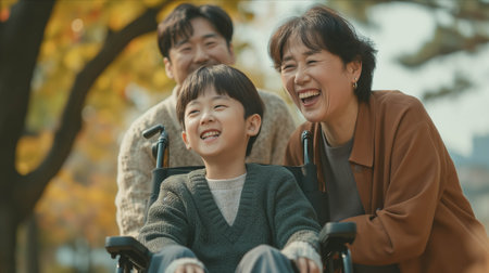 Asian father and mother take care of disabled son in wheelchair in park.の素材