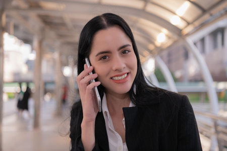 Caucasian businesswoman talking on mobile phone in city.の写真素材