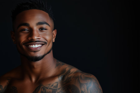 African American man has tattoos on his body on black background.の素材