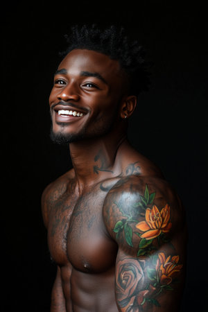 African American man has tattoos on his body on black background.の素材