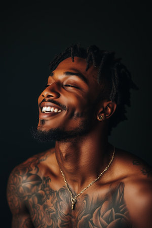 African American man has tattoos on his body on black background.の素材