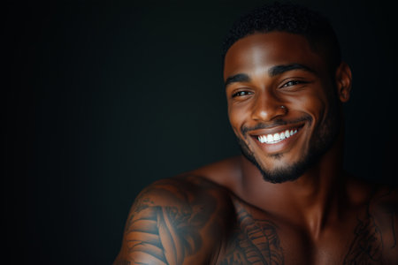 African American man has tattoos on his body on black background.の素材