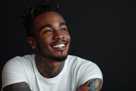 African American man has tattoos on his body on black background.の素材