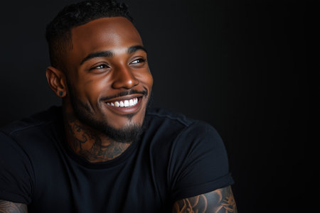 African American man has tattoos on his body on black background.の素材