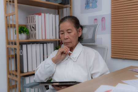 Thoughtful woman working on a tablet in office.