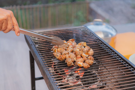 A person grilling delicious seafood on a barbecue, capturing the essence of outdoor cooking and summer joy.の写真素材
