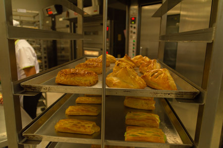Freshly baked pastries cooling on a rack in a professional kitchen, showcasing delicious textures and colors.の写真素材