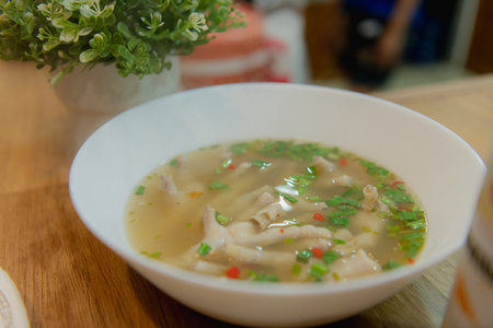 Delicious bowl of soup topped with fresh herbs and spices, perfect for a comforting meal.の写真素材