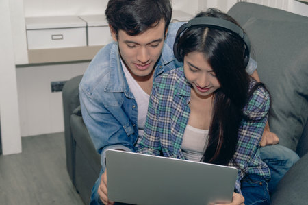 A couple enjoys quality time together while watching something on a laptop, showcasing intimacy and connection.の写真素材