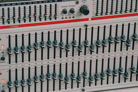 Detailed view of a professional audio mixer with sliders and controls, showcasing intricate sound engineering.の写真素材