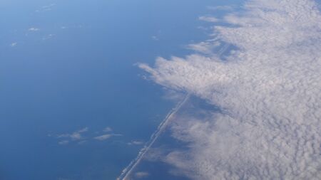 High panoramic view from an airplane. With clouds. See the ocean